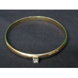9ct gold bangle set with single Diamond in a raised decorated square shaped setting (24.2g) Please