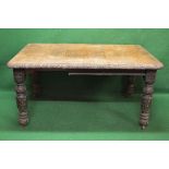 Oak wind out dining table having carved border and standing on carved turned legs ending in