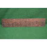 Rectangular carved hardwood panel being carved with tribal figures and cattle with a carved border -