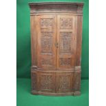 19th century oak floor standing corner cupboard having bow front and carved doors opening to