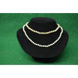 Two pearl necklaces formed of single rows of uniform sized pearls and having 9ct gold clasps - 20.5"