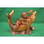 Hardwood carved figure of a young child riding on the belly of a Dolphin, standing on a carved