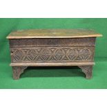 Oak coffer the top opening to reveal storage space and having carved front, standing on carved