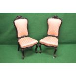Pair of rosewood nursing chairs having showwood frames with padded backs and seats, standing on