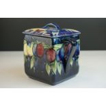 Moorcroft Biscuit Barrel in the Wisteria pattern on a blue ground, restoration to lid, Moorcroft