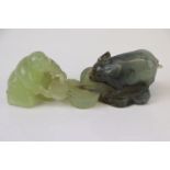 An oriental carved Jadeite figure of a man feeding a pig.