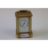 A brass cased miniature carriage clock with white enamel dial (A/F), marked hands to verso.
