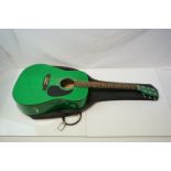 A green Stagg acoustic guitar and case.