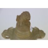 An oriental carved Jadeite lidded urn with Foo dog to the lid and hardwood base.