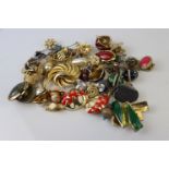 A box of mixed costume jewellery to include brooches and earrings.