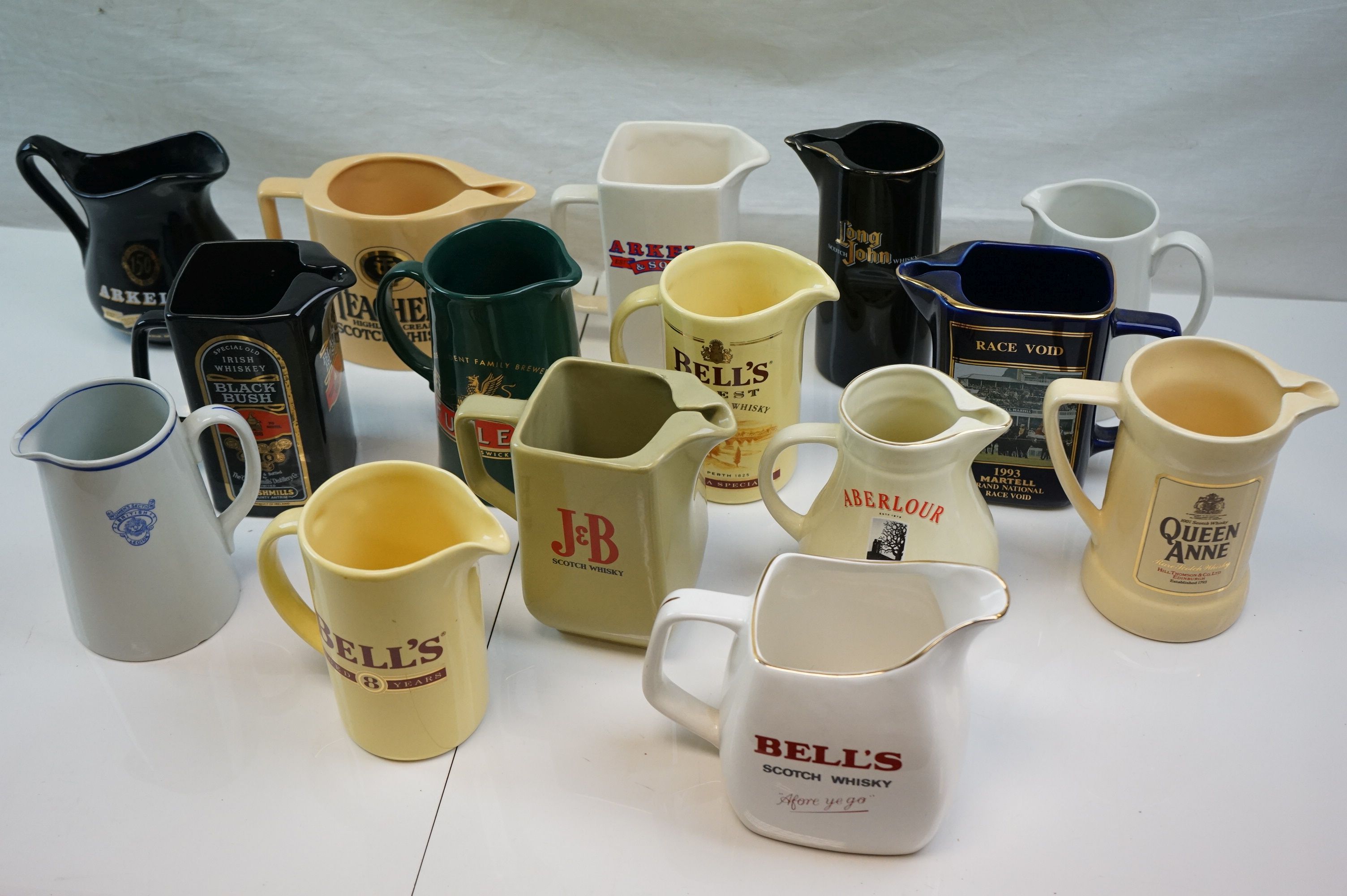 Collection of Fifteen Ceramic Pub Advertising Jugs including Wade and Martell Grand National Void