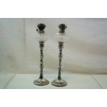 A pair of silver plated oil lamps of classical form with cut glass wells.