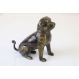 A bronze figure of a seated dog.