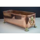 Copper Rectangular Planter with Brass Lion Mask Ring Handles and raised on four brass lion paw feet,