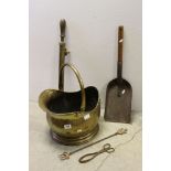 A brass coal scuttle a coal shovel and scissors a toasting fork and garden sprayer.