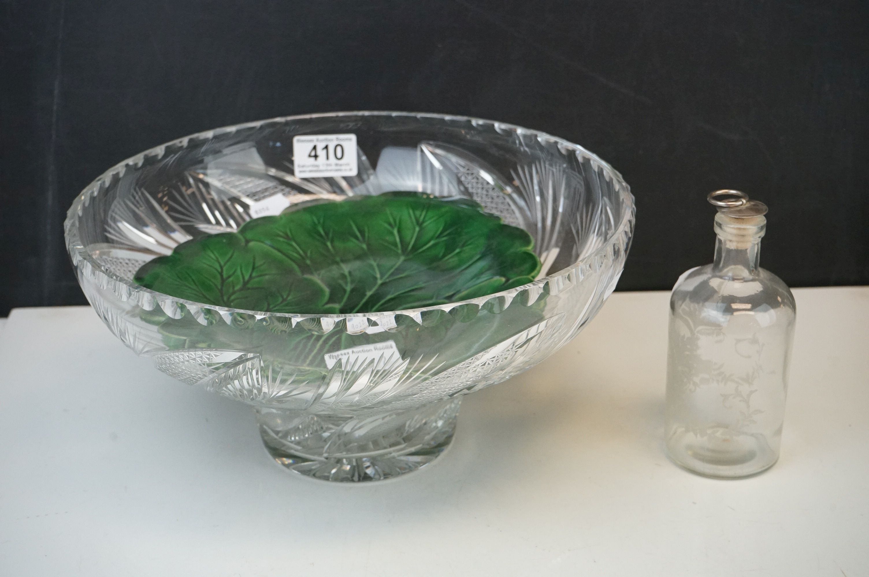 A cut glass fruit bowl an antique green leaf plate together with an etched glass bottle with