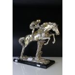 A contemporary plated figure of a jockey and horse jumping hurdle signed.