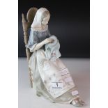 A Lladro figure of a seated woman Embroidering.