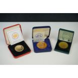 A collection of three cased commemorative coins.