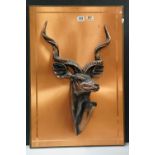 A copper effect plaque mounted with a sculpture of an Antelope.