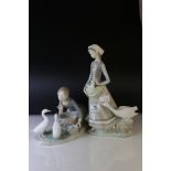 A Lladro figure of a girl feeding white ducks and one other girl with goose and goslings .