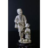 A Japanese carved ivory sectional okimono of a farmer and son, the man holding an axe in his left