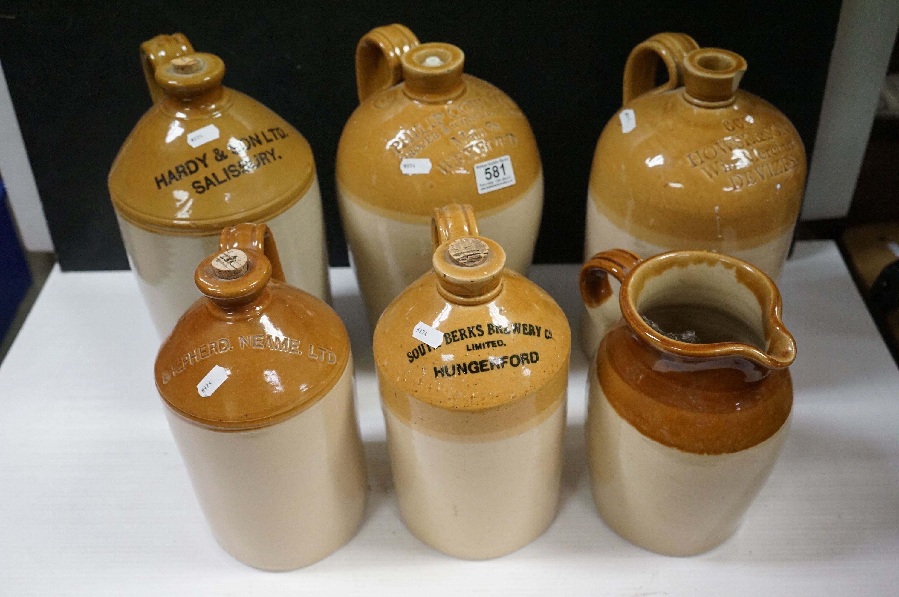 Six antique stoneware flagons to include Wexford, Devizes Bradford etc and a similar jug.