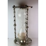 A large novelty metal and glass egg timer