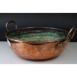 An antique brass and copper two handled pan.