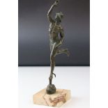 An antique bronze statue of Hermes mounted on a marble base.
