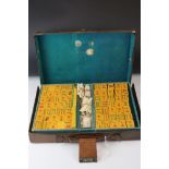 A mid 20th century leather cased Mahjong set tile and bone counters.