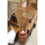 A contemporary ceramic brown vase with grasses.