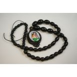 A vintage bog oak necklace with hand painted centre pendant.