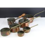 A set of antique graduated copper saucepans.