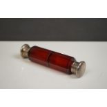 A Victorian ruby glass double ended scent bottle with fully hallmarked sterling silver lids.