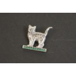 Silver cat brooch on emerald style platform base
