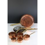 A set of graduated copper sauce pans together with a set of graduated copper frying pans.