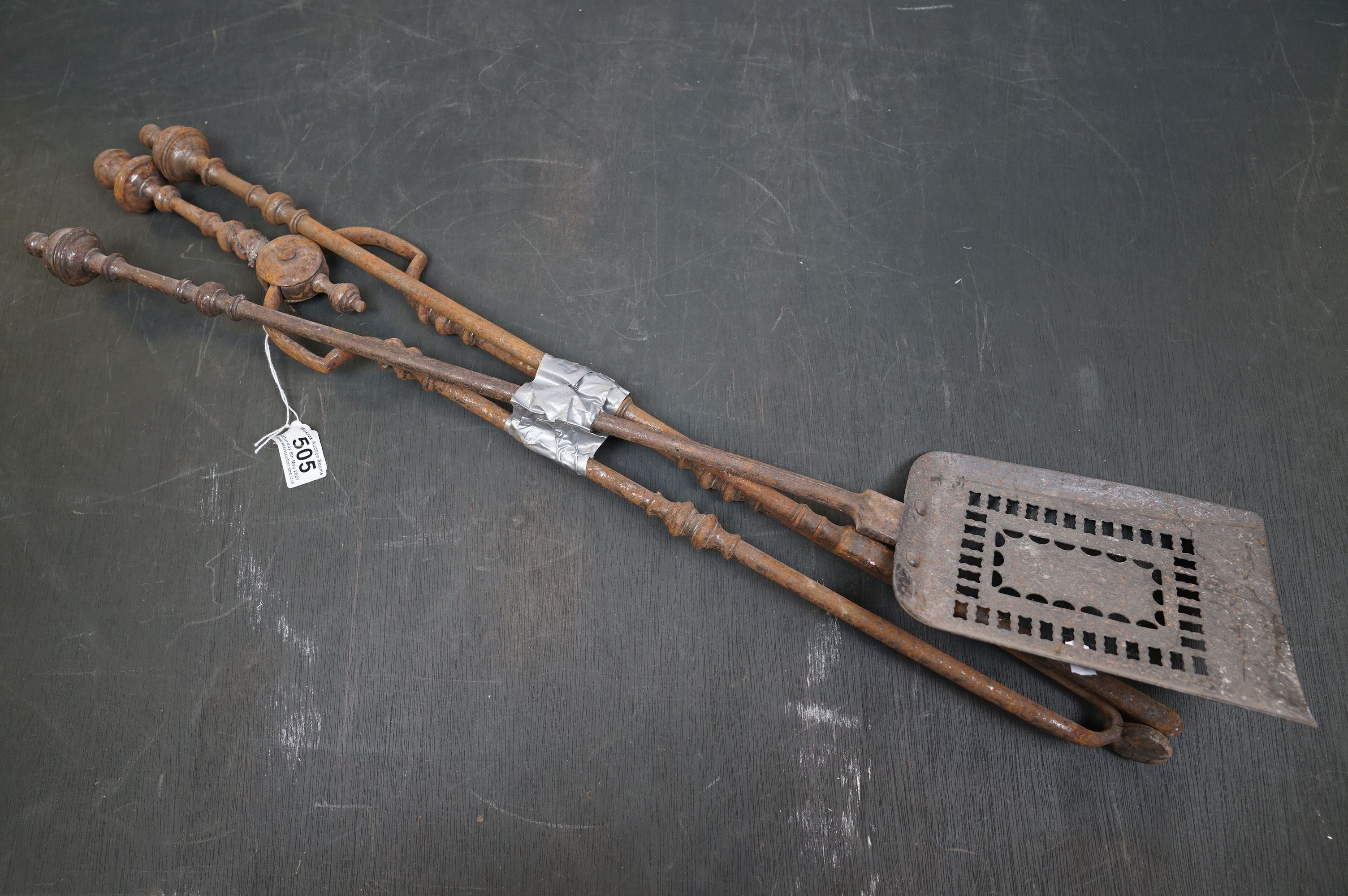 A vintage iron three piece fire tool companion set comprising of shovel, poker and tongs.