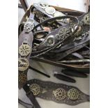 A large collection of vintage horse brasses with leather straps.
