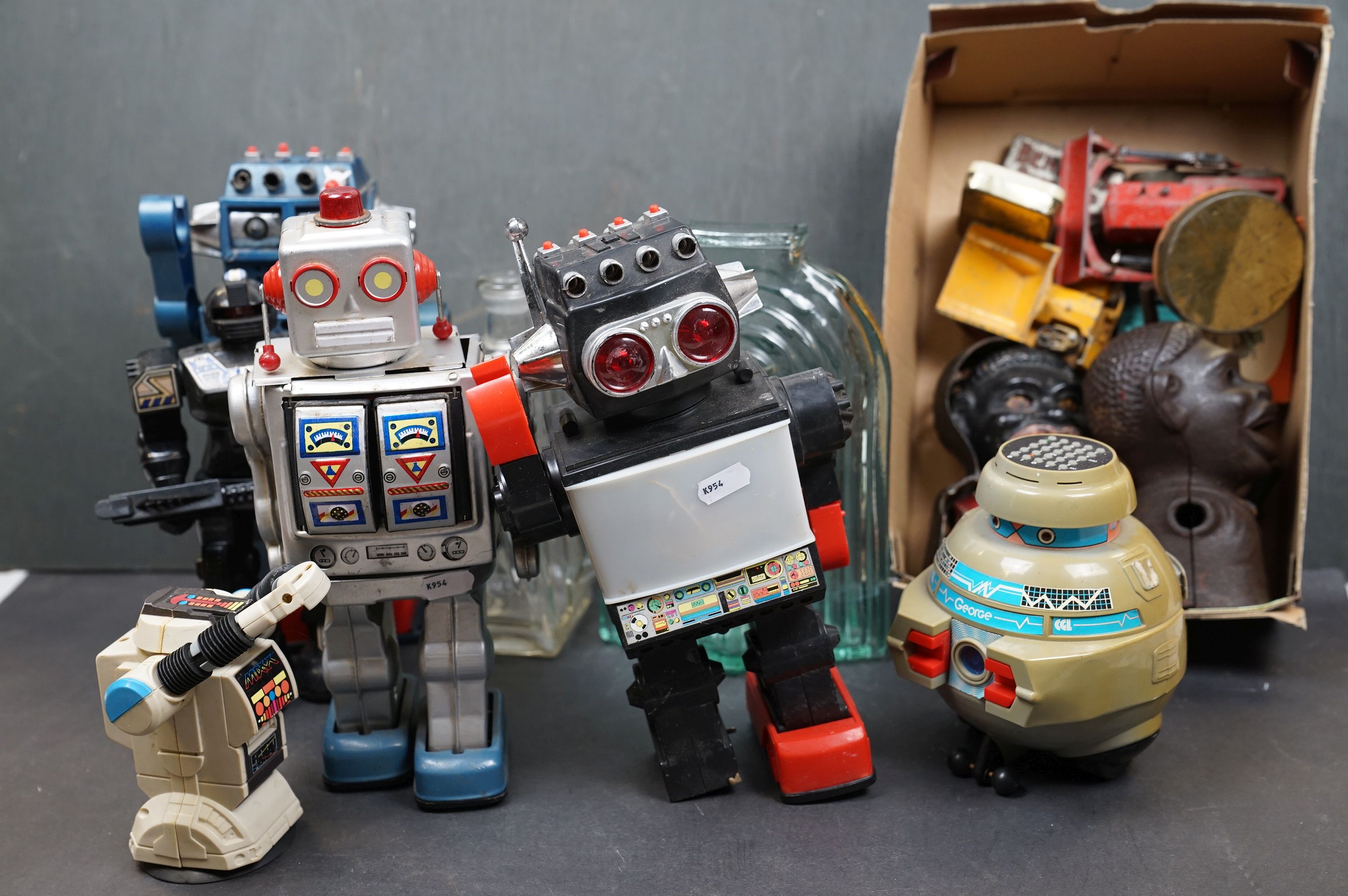 A box of mixed collectables to include battery operated robots, iron money boxes and Dinky diecast