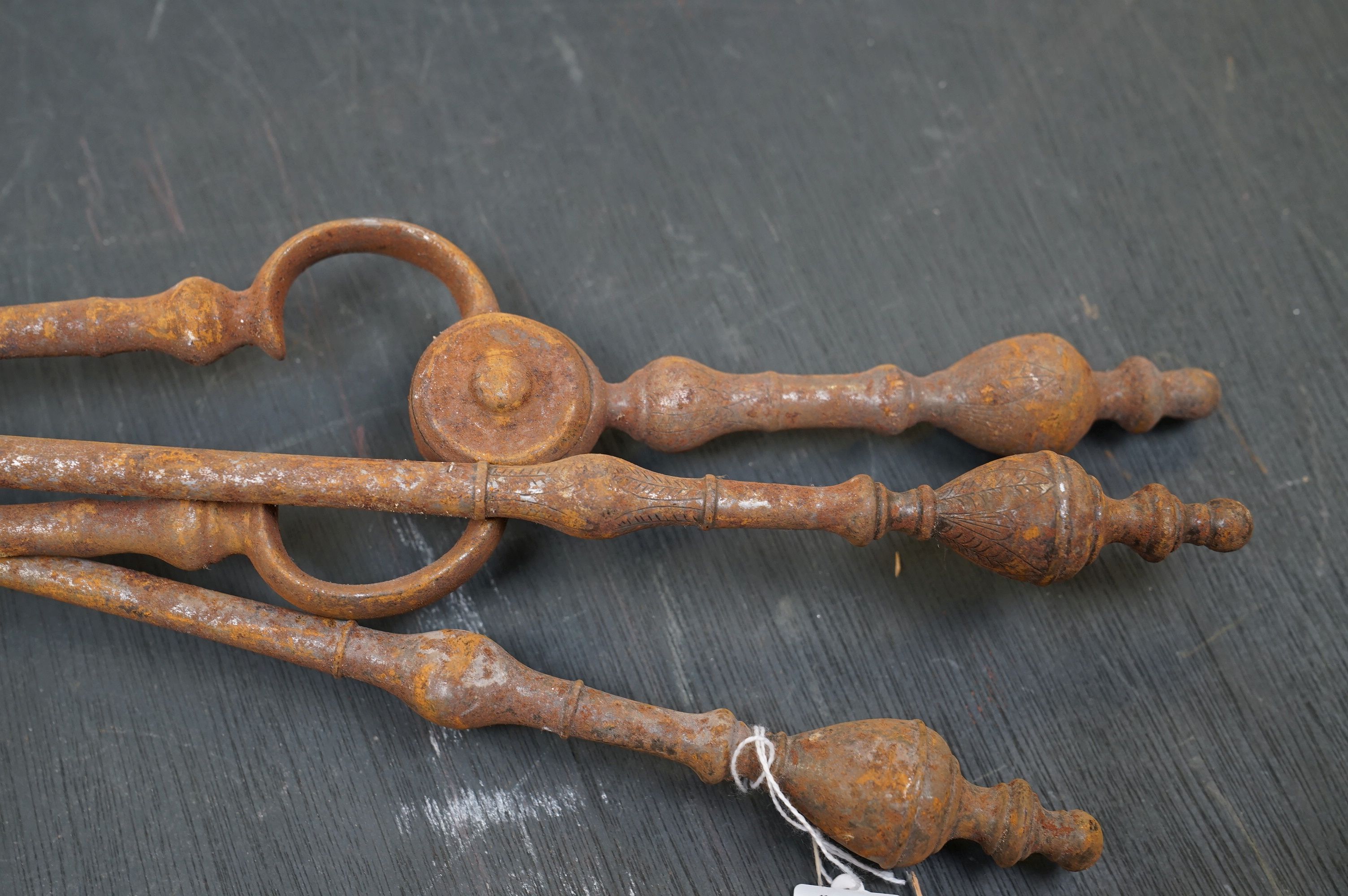 A vintage iron three piece fire tool companion set comprising of two shovels and a pair of tongs. - Image 4 of 6