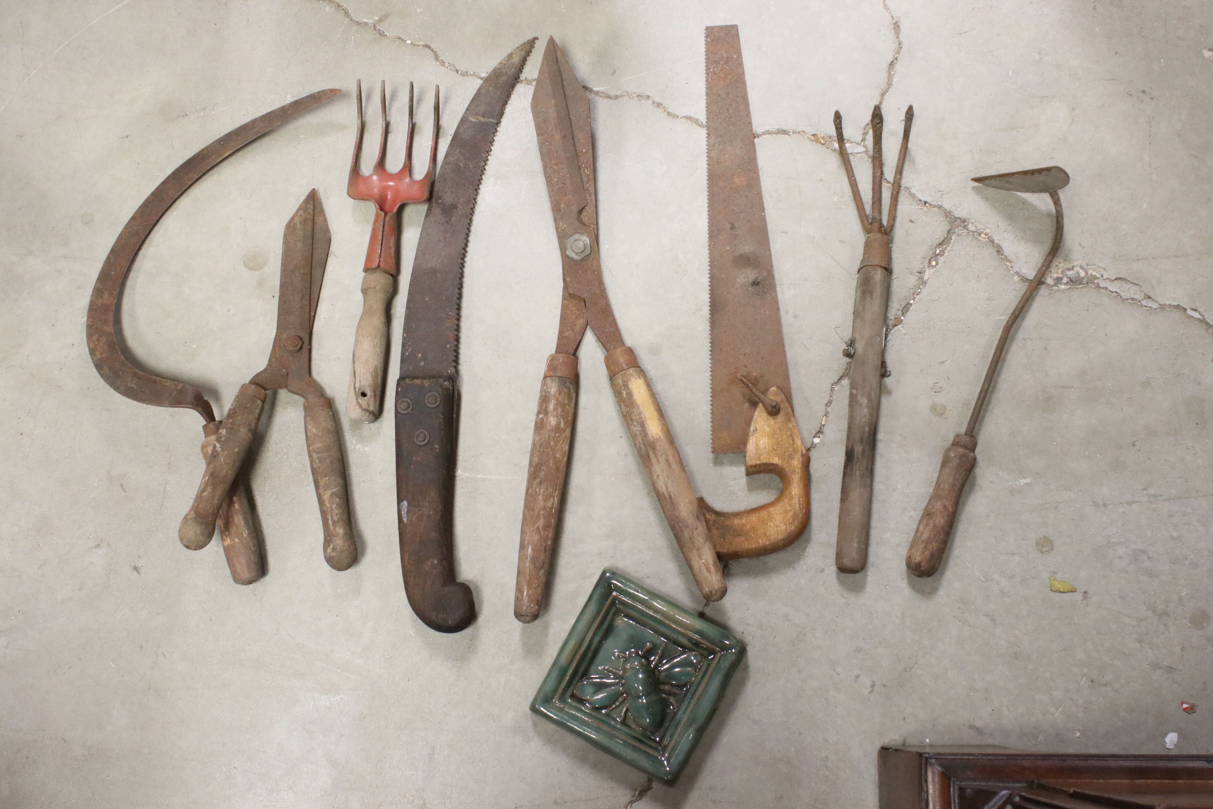 A small group of vintage gardening tools to include shears and saws.