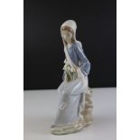 Lladro figure of a lady sitting on rocks with calla lilies in her lap