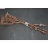 A vintage iron three piece fire tool companion set comprising of two shovels and a pair of tongs.