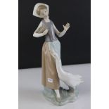 Lladro figure of a lady holding a bowl of feed for goose at her feet