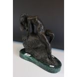 Bronze figure of a nude woman reclining on a rock, on a green marble base