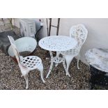 A white metal graden table with two matching chairs.