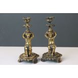 A pair of 19th century brass candlesticks in the form of cherubs.