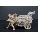 An antique Dresden bone china of two winged cherubs together with chariot.
