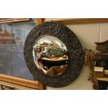 Arts and Crafts Convex Mirror with a metal frame with relief leaf decoration, 56cms diameter